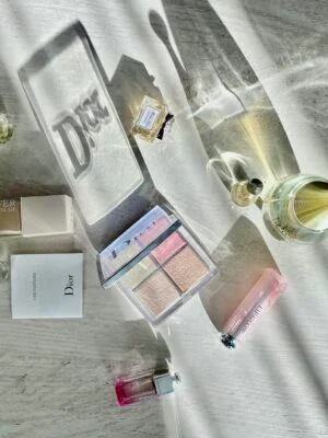 High-angle shot of Dior cosmetics and perfumes casting artistic shadows.