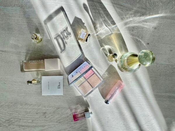 High-angle shot of Dior cosmetics and perfumes casting artistic shadows.