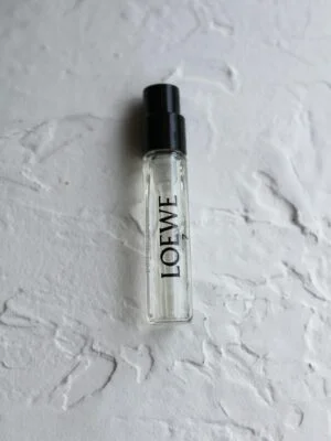 Loewe perfume sample bottle on textured surface, showcasing elegant packaging design.